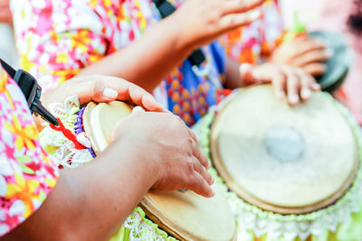 Midsection of people playing djembes during parade