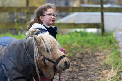 Girl with horse on field