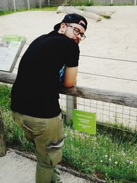 Side view of young man standing by plants