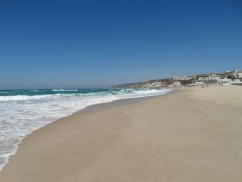 View of beach against clear blue sky