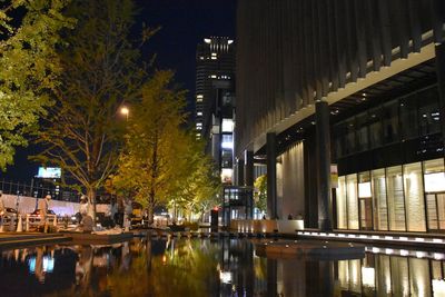 Reflection of illuminated buildings in city at night