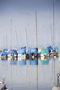 Sailboats moored in lake against sky