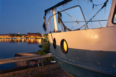 Boat moored in lake against clear blue sky