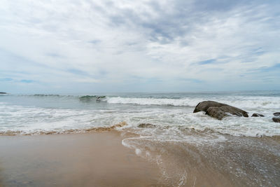 Waves and large rocks on the beach. cloudy sky, arugam bay, sri lanka