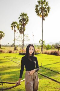 Portrait of young woman standing on field