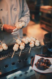 Midsection of person preparing food on barbecue grill