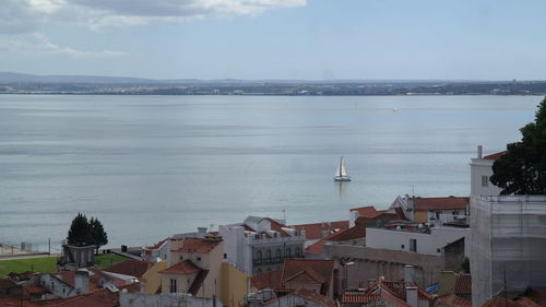 High angle view of townscape by sea against sky