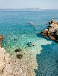 Man floating on water on beautiful beach with turquoise water on pag island in croatia.