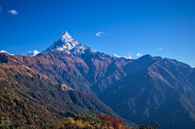 Scenic view of mountains against blue sky