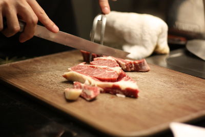 Cropped image of person preparing food on cutting board