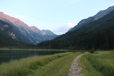 Scenic view of lake by mountains against sky