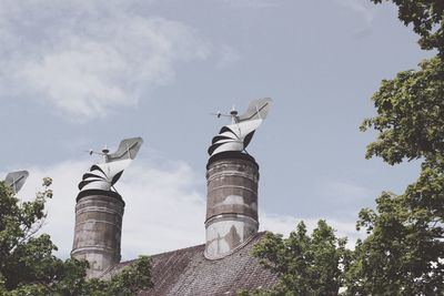 Low angle view of birds flying against sky