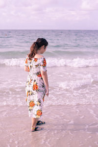 Full length of woman at beach against sky