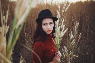 Portrait of young woman wearing hat on field