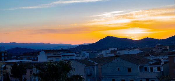 Townscape against sky during sunset