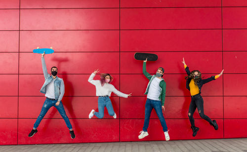 Full length of people standing against wall