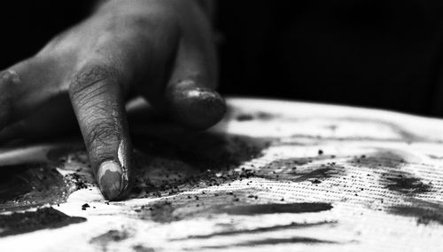 Cropped hand of artist painting paper