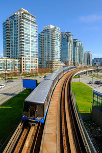 High angle view of railroad tracks amidst buildings in city against sky