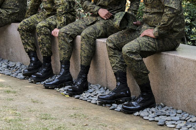 Low section of soldiers sitting outdoors