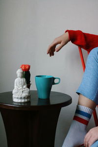 Buddha statue with coffee cup on table