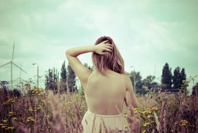 Woman standing on field against sky