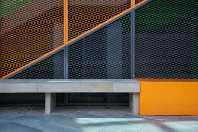 Metal fence against orange wall of building