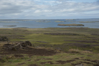 View of calm lake against cloudy sky