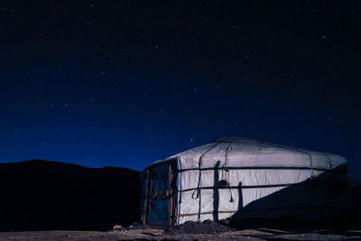 Abandoned building against blue sky at night