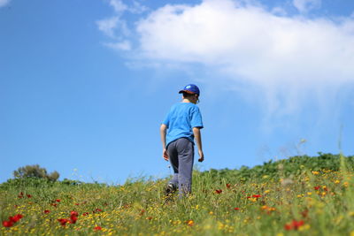 Man standing on field against cloudy sky