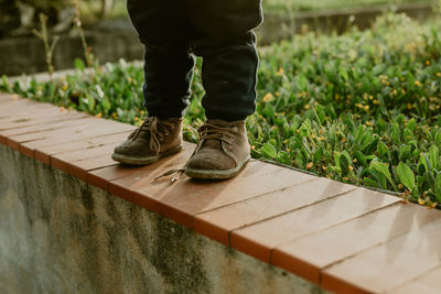 Low section of man standing on boardwalk