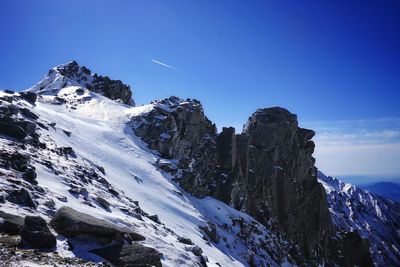 Scenic view of snowcapped mountains against clear blue sky