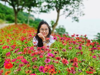 Portrait of smiling woman with red flowers