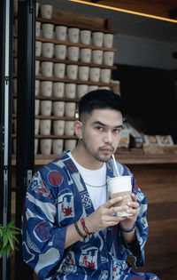 Portrait of man holding coffee cup