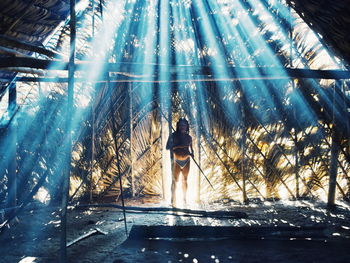 Rear view of woman standing by water