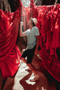 Rear view of man standing with red umbrella