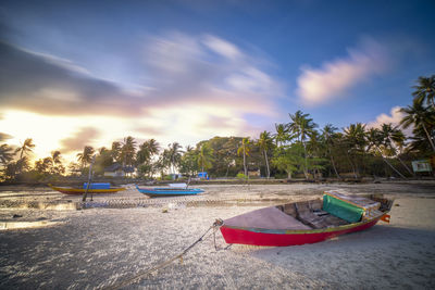 Boats moored on beach against sky