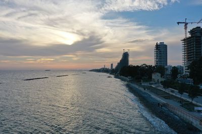 Scenic view of sea and buildings against sky during sunset