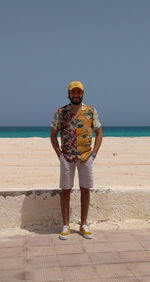 Full length of boy standing on beach against clear sky