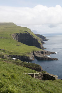 Scenic view of landscape by sea against sky