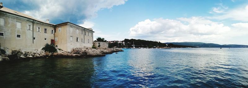 Panoramic view of sea and buildings against sky