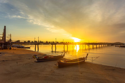 Boats moored in sea at sunset