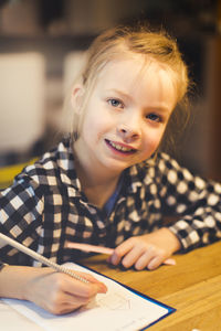 Close-up portrait of girl studying at table