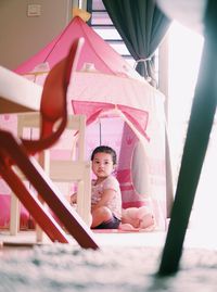 Portrait of girl sitting in pink dress