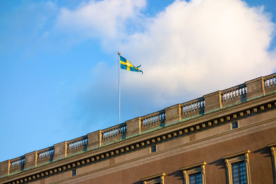 Low angle view of flag against building against sky