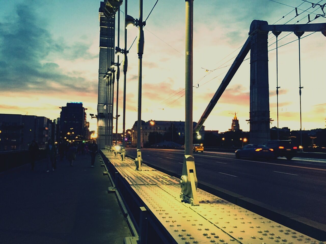 sunset, transportation, architecture, sky, built structure, railroad track, building exterior, city, railroad station, cloud - sky, rail transportation, mode of transport, railroad station platform, public transportation, travel, orange color, connection, city life, land vehicle, cloud