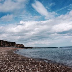 Scenic view of beach against blue sky
