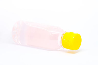 Close-up of yellow bottle against white background