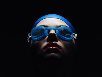 Close up of female swimmer against black background