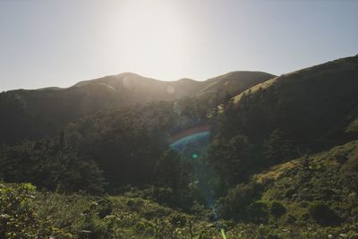 Scenic view of rainbow over mountains against clear sky