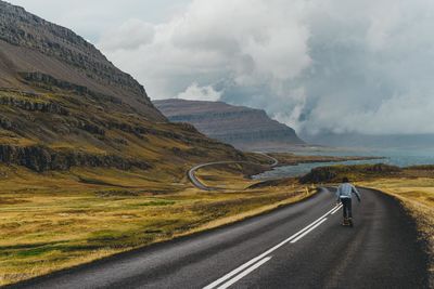 Scenic view of mountain road against stormy clouds